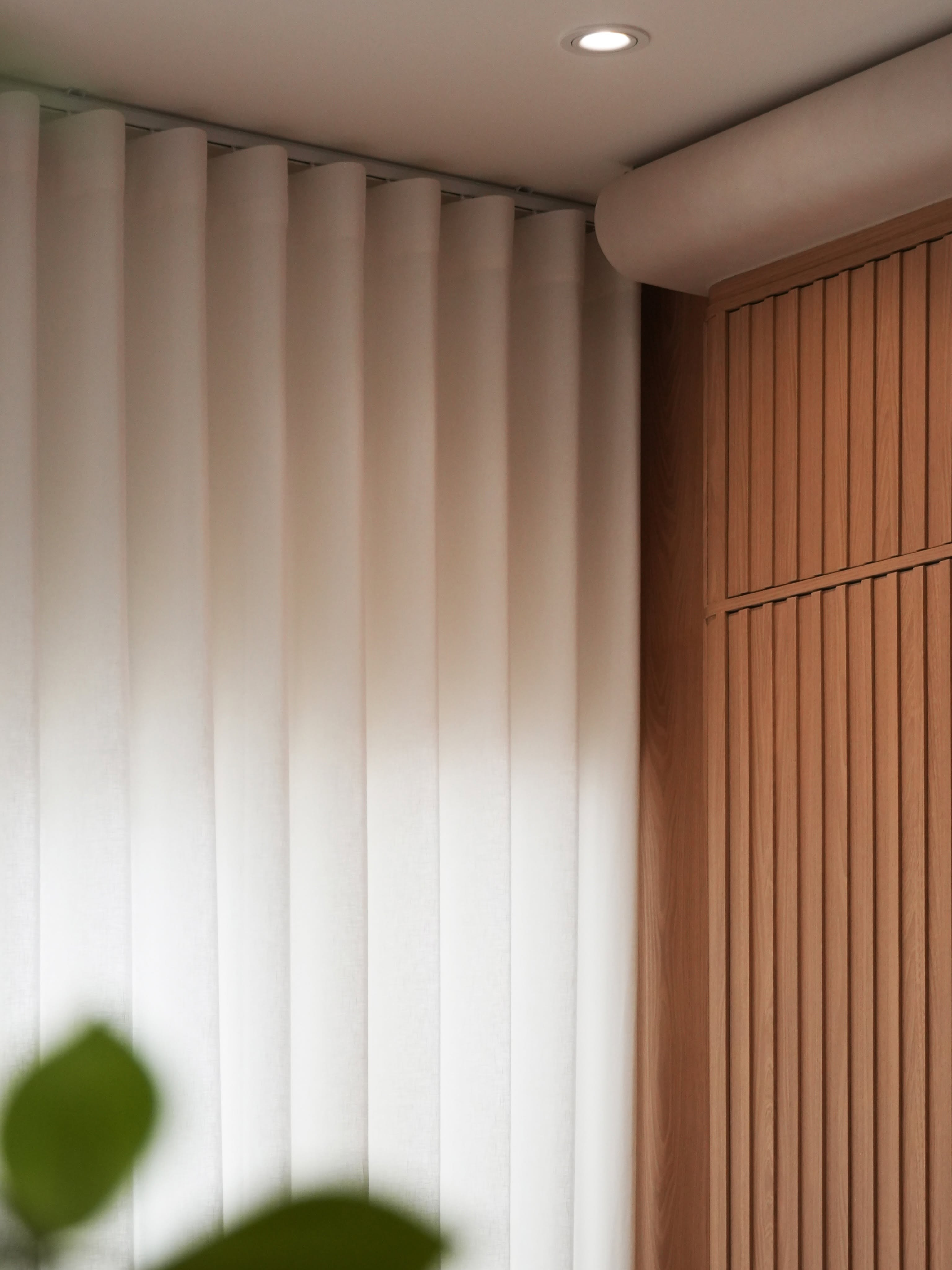 Soft architectural drapery beside timber panelling